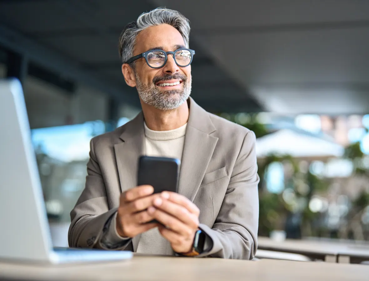 man looking away while holding his phone