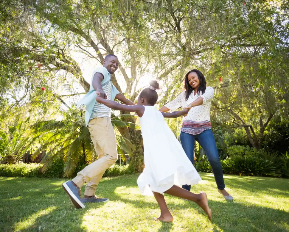 Mother, father and daughter playing in their backyard