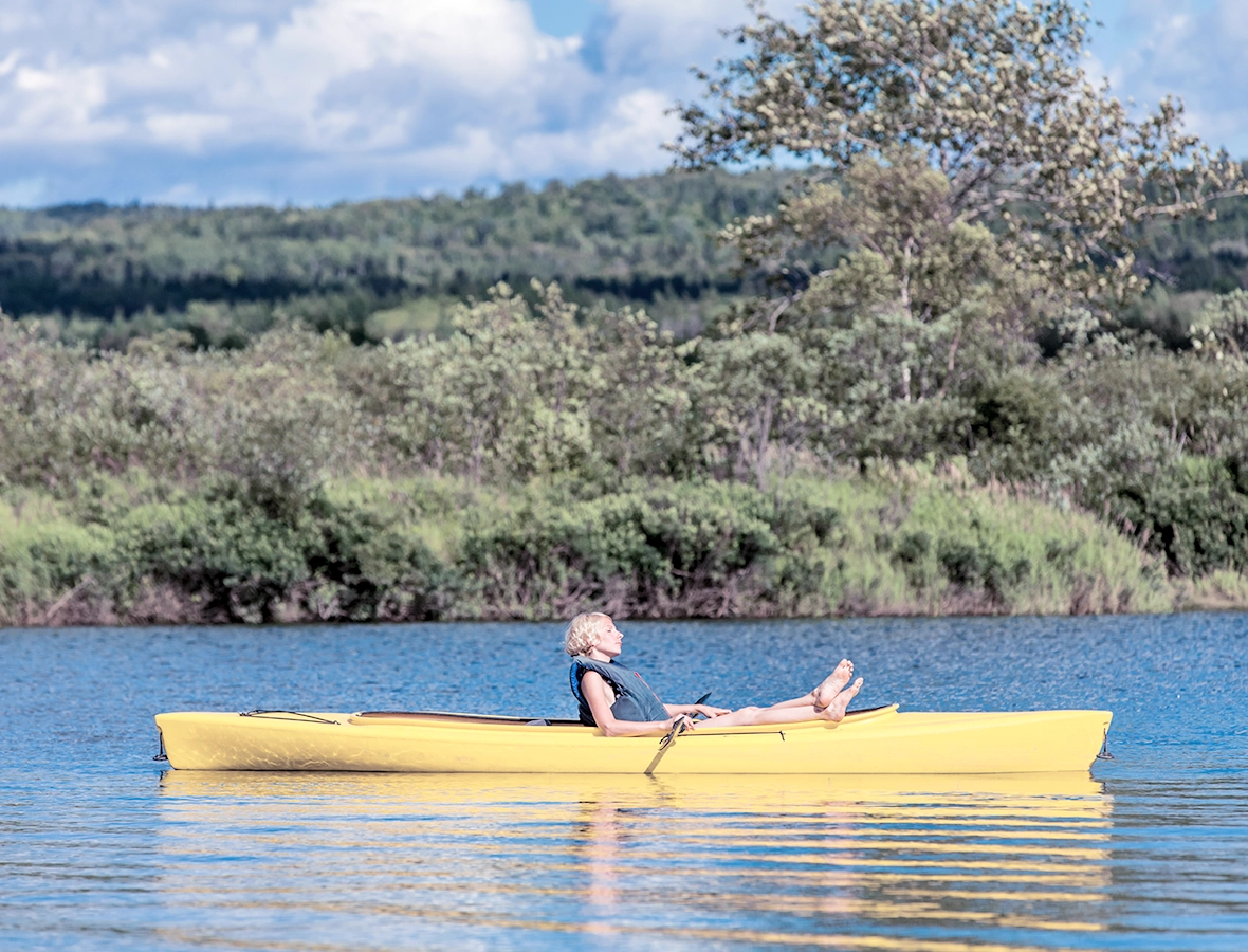 Person kayaking in a lake and relaxing