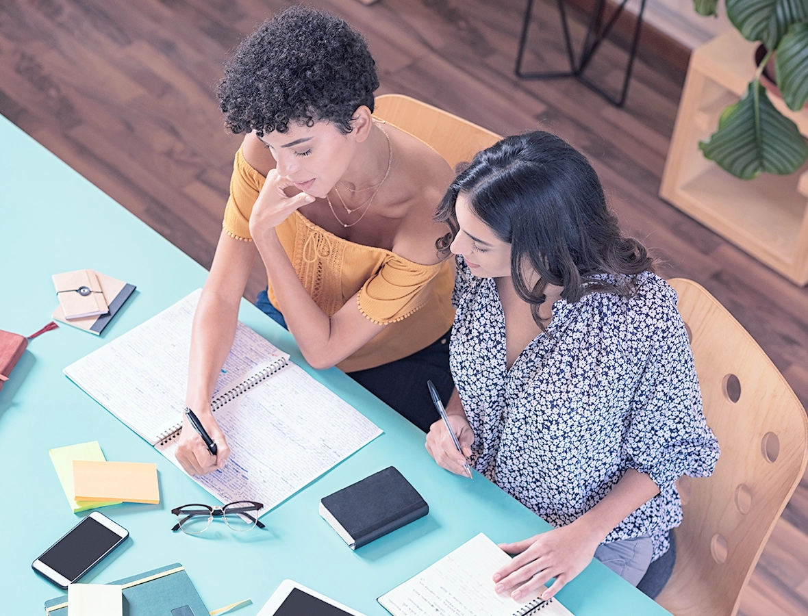 Two women discussing how to start managing your debt.