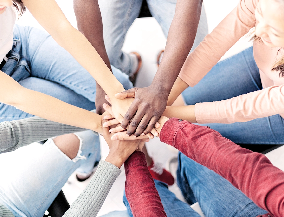 Team with their hands together in a huddle