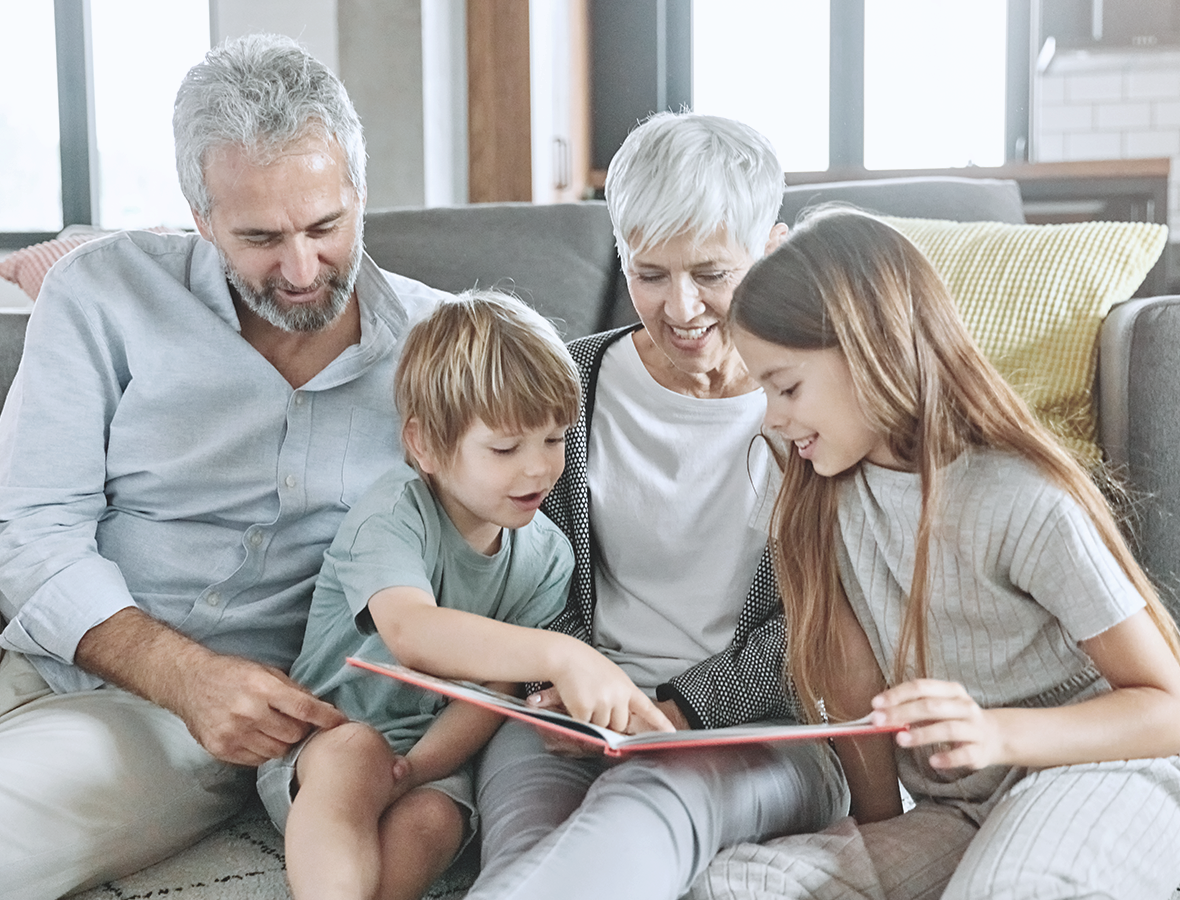 Grandparents reading a book with their grandkids