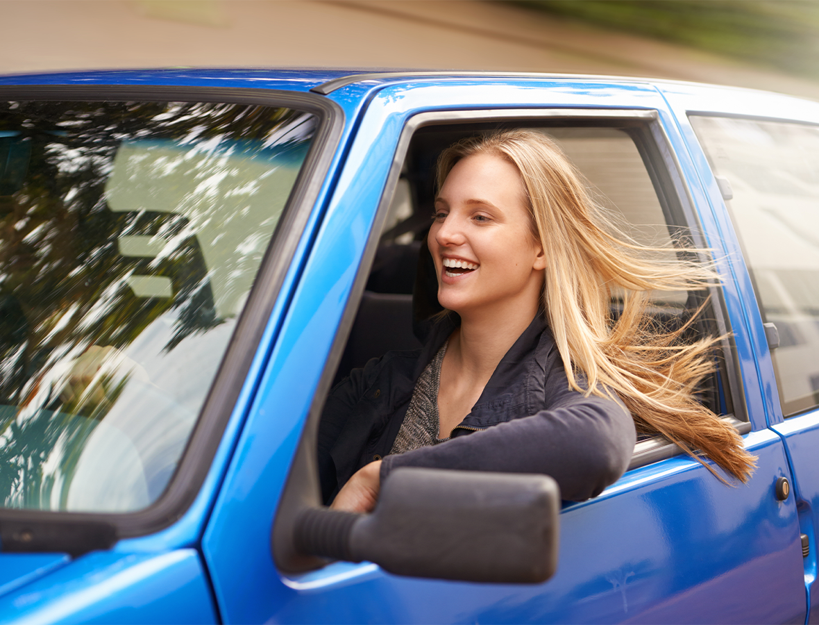 Young woman in new car using Budget Friendly Car Financing Tips.