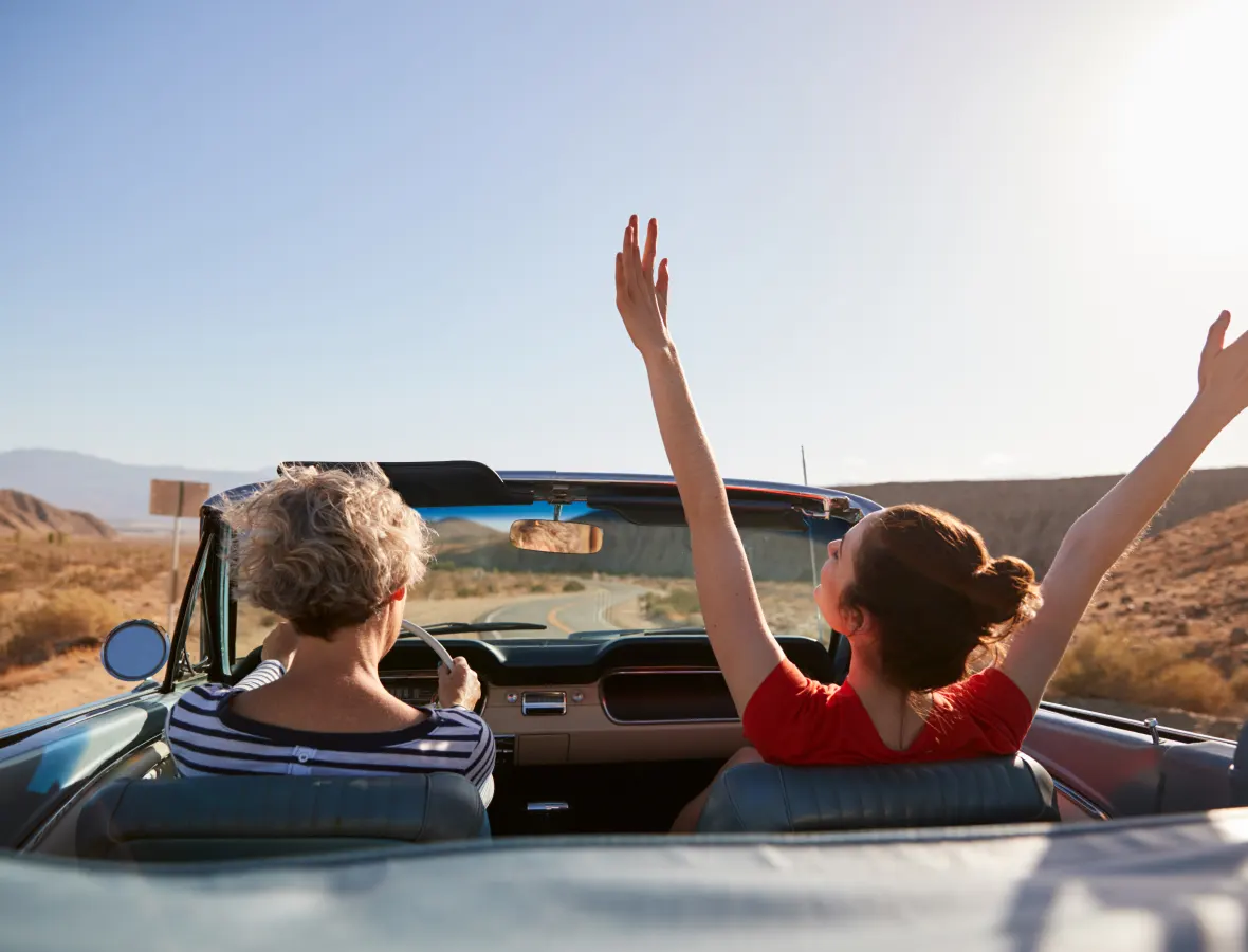 Mom and Daughter driving a convertible in the desert