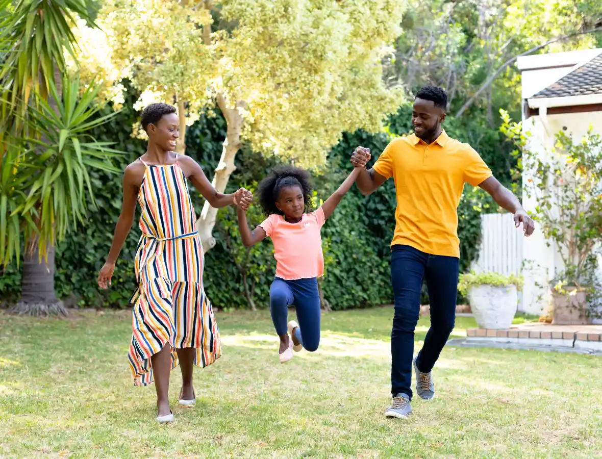 Mom, dad, and their daughter playing in their yard