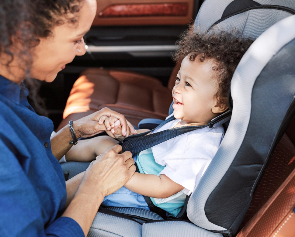 A mom buckle her child into the car seat