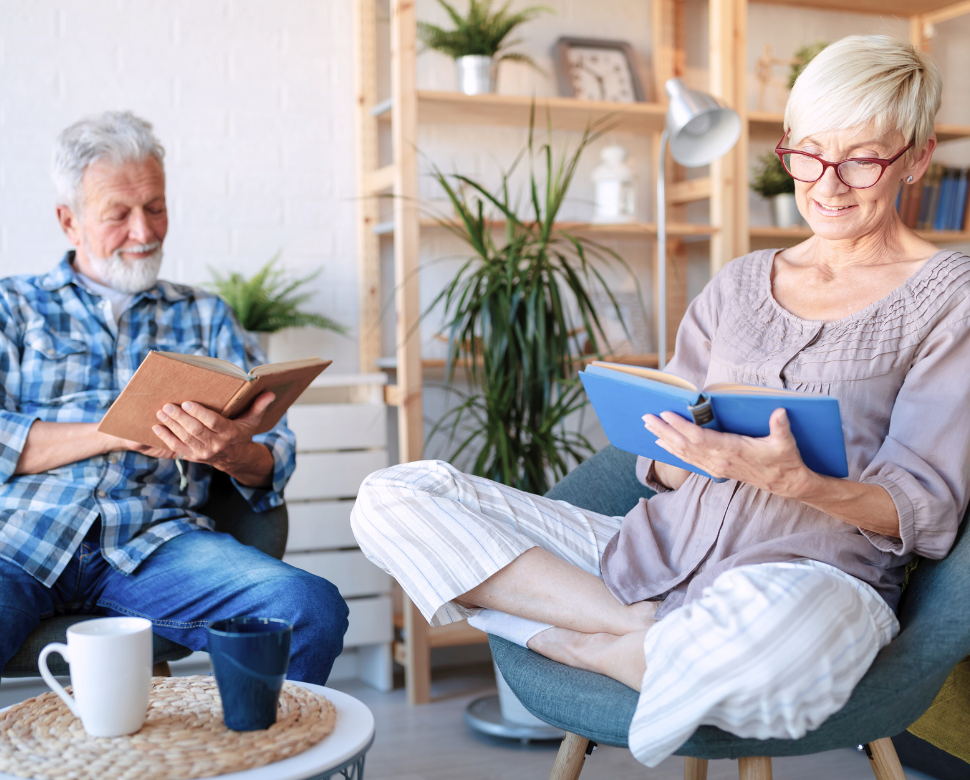 Older couple sitting in their house and reading