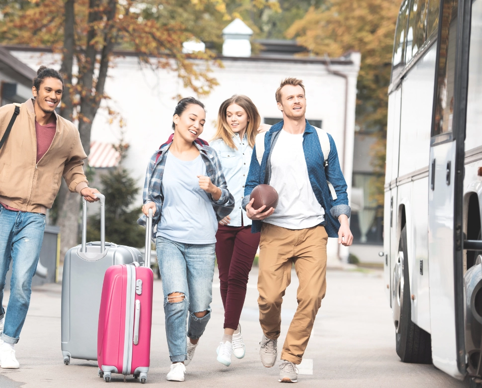 College students with luggage hopping on a bus