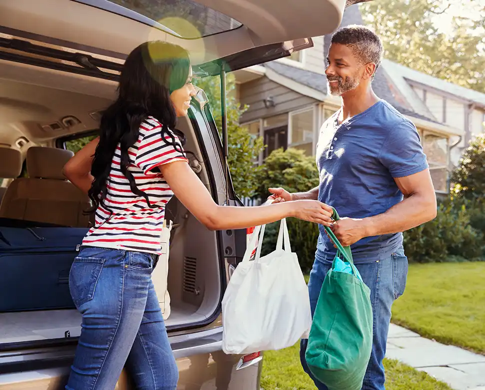 Couple taking shopping out of their car trunk