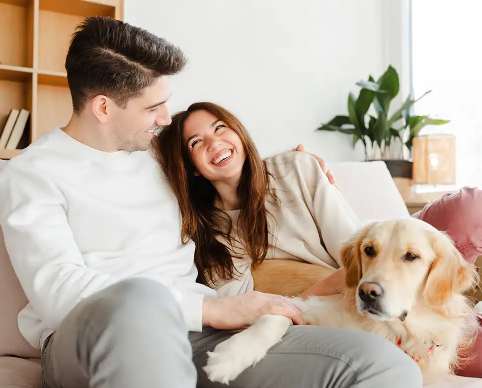 Couple sitting on couch with their dog